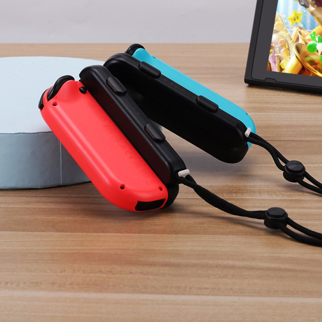 Red and black game controllers on a wooden surface with a blurred background
