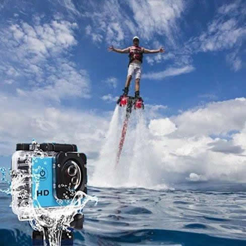 Person on a flyboard with a camera underwater in the foreground, against a blue sky and ocean background.