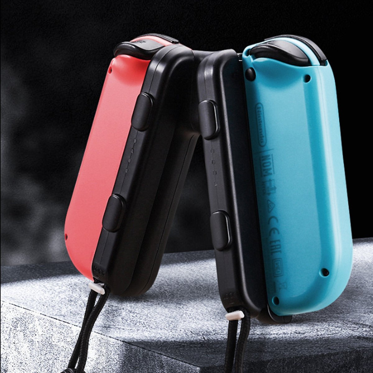 Two folding knives, one red and one blue, on a dark background.