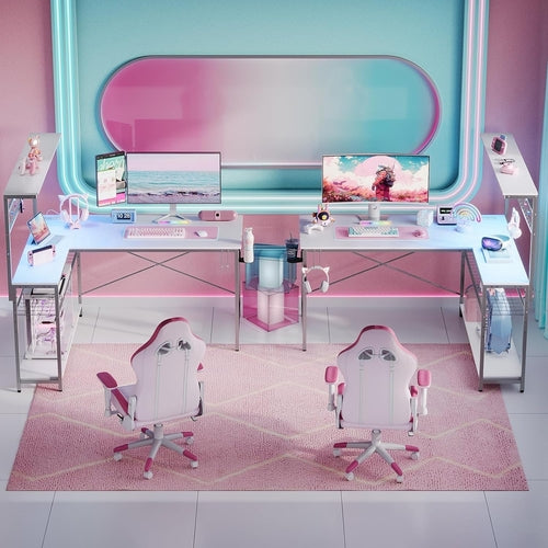 Modern office setup with a pink and white color scheme, including a L-shaped desk, chairs, and computer monitors.