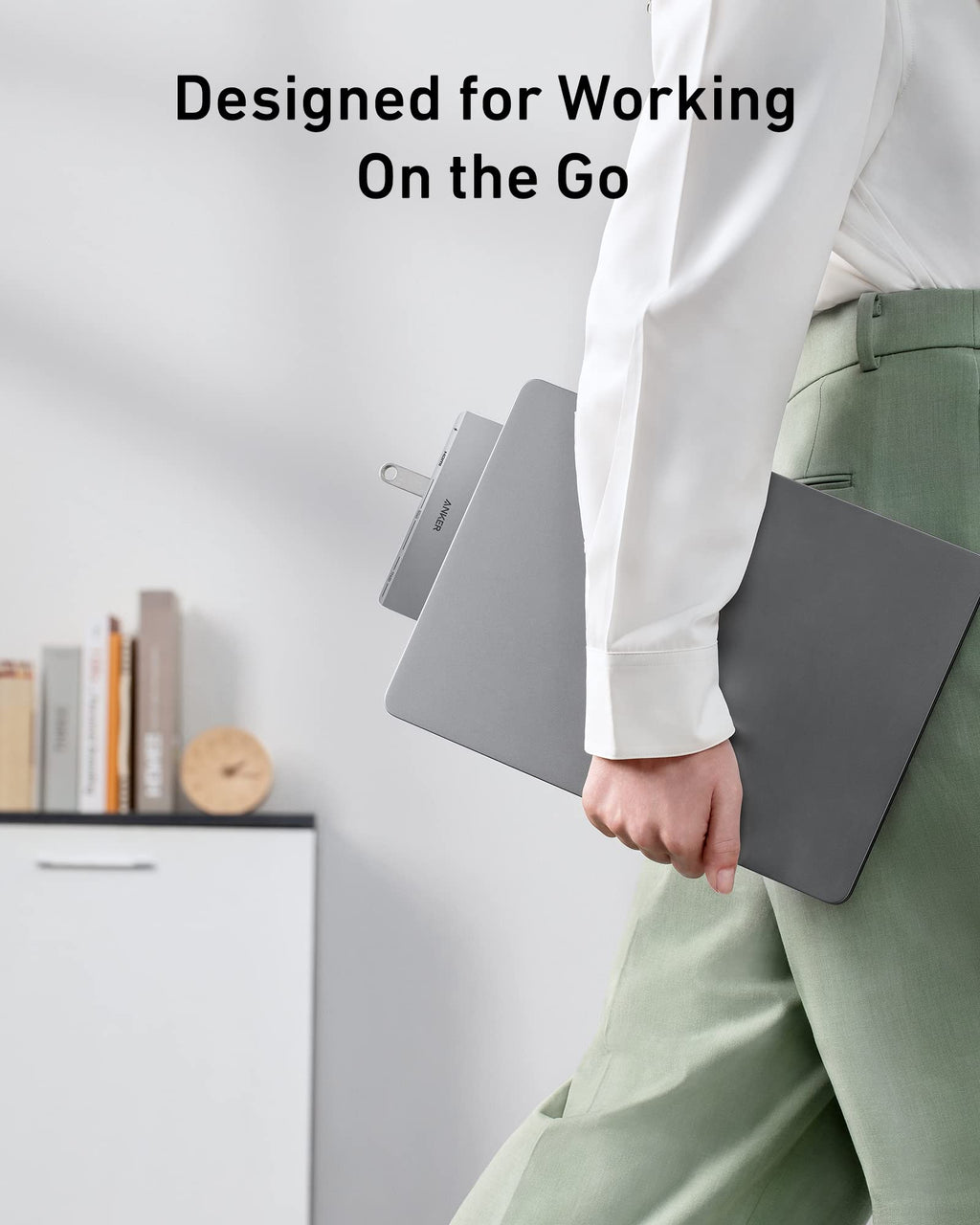 Person holding a gray laptop case with text 'Designed for Working On the Go' on a light background
