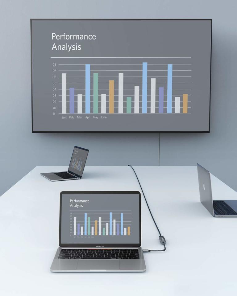 Laptop displaying performance analysis on a screen with bar graphs, placed on a white surface.
