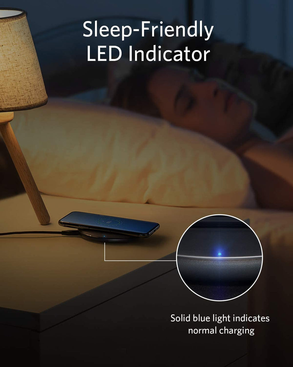 Phone with sleep-friendly LED indicator on a nightstand next to a lamp.