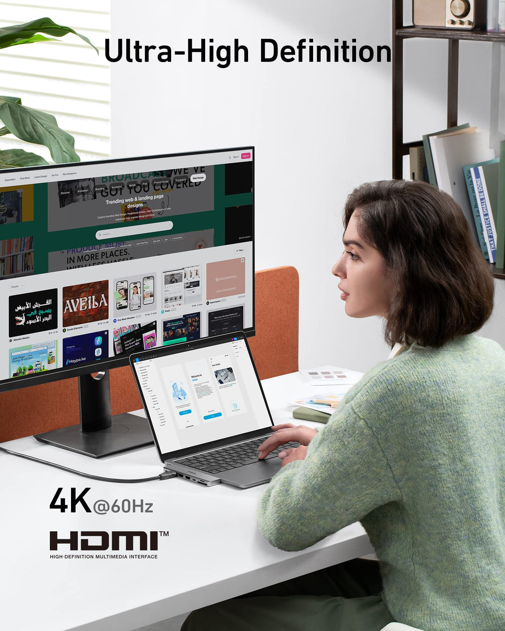 Person using a laptop with a large monitor displaying multiple web pages, emphasizing Ultra-High Definition and HDMI technology.