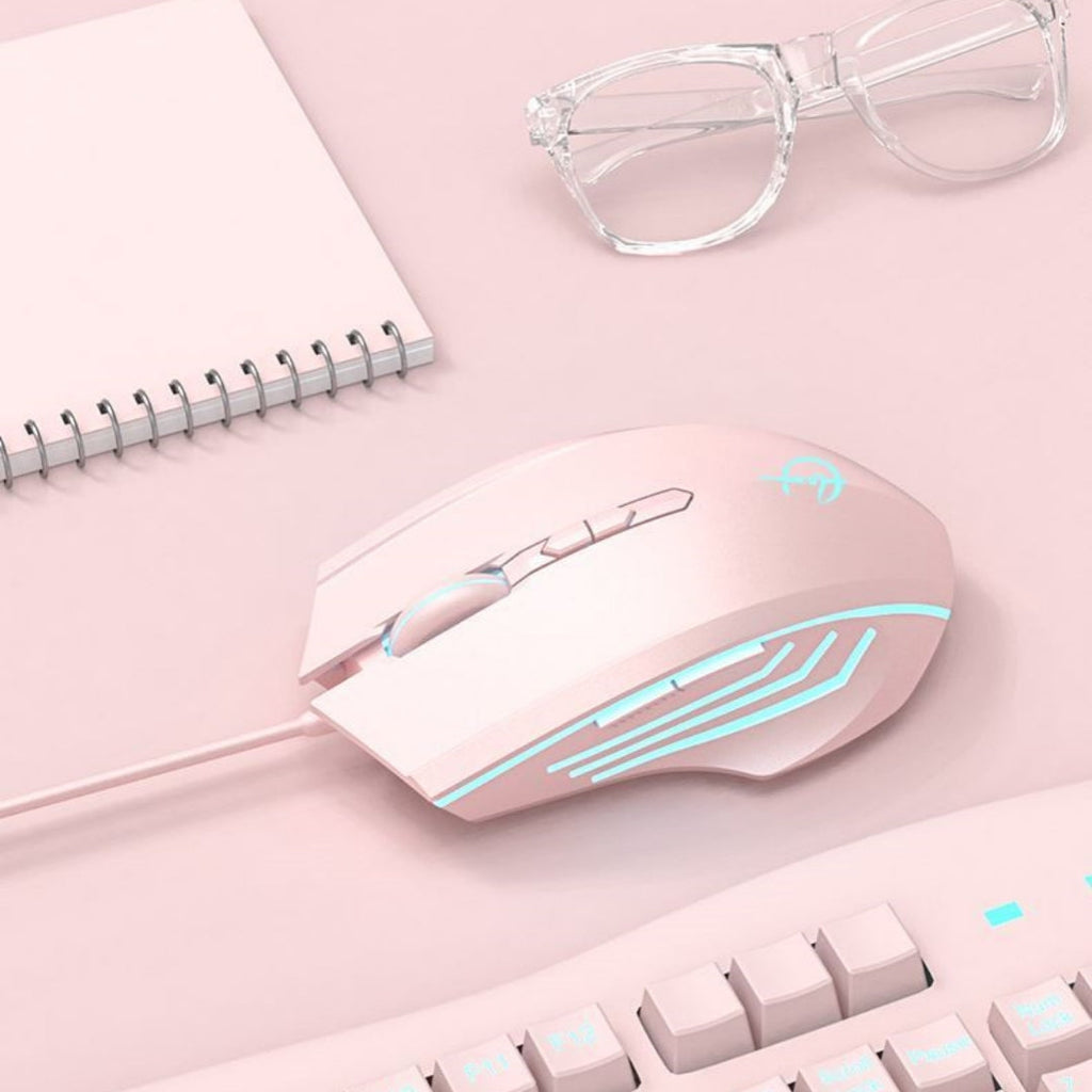 Pink gaming mouse with blue lighting on a pink surface with a notebook and glasses.