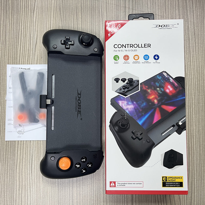 Black gaming controller with Dobe branding next to its packaging on a wooden surface