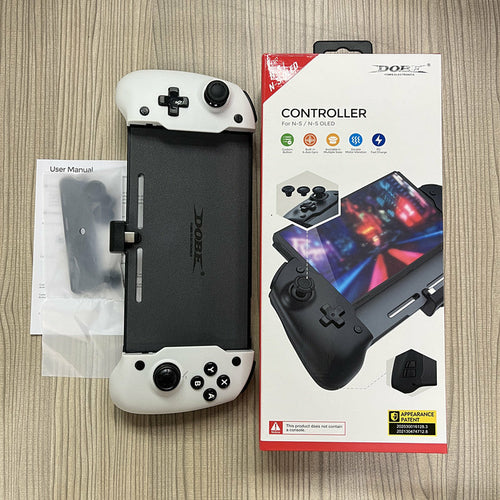 Gaming controller with packaging and user manual on a wooden surface