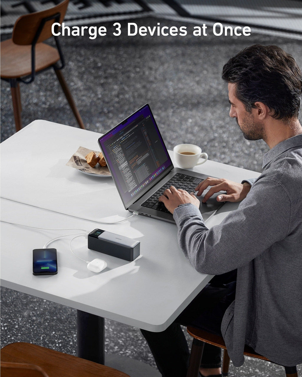 Person using a laptop with a device charging station on a table, text 'Charge 3 Devices at Once' above.
