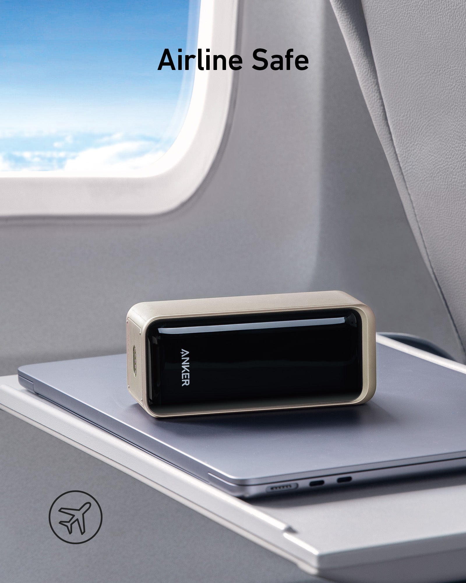 Anker power bank on a tray table with airplane window in the background