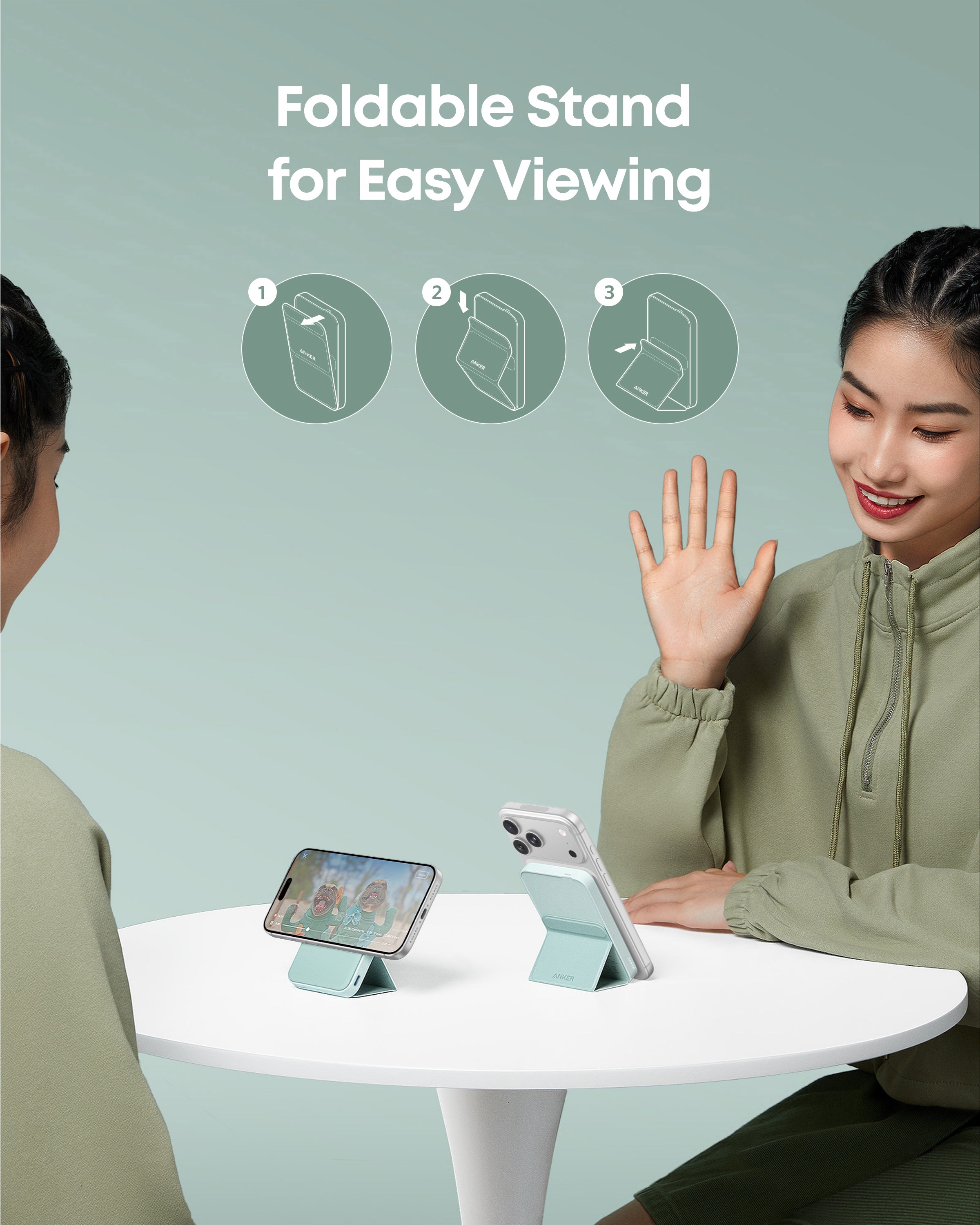 Foldable stand being used to view a phone screen between two people with a light green background.