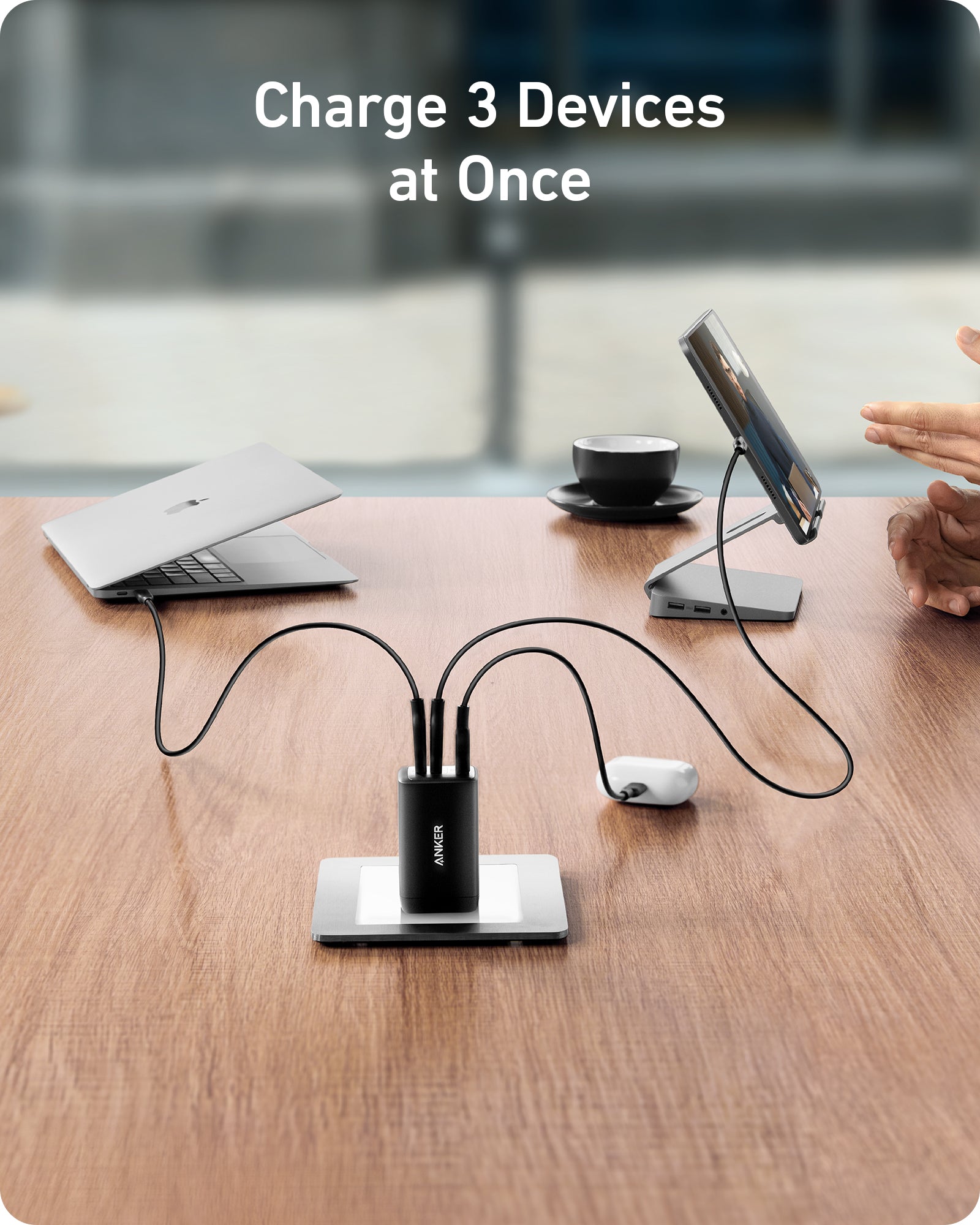 USB hub charging three devices on a desk with a blurred office background