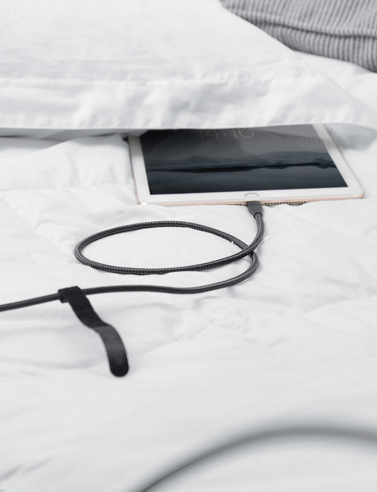 Tablet with a charging cable on a white surface