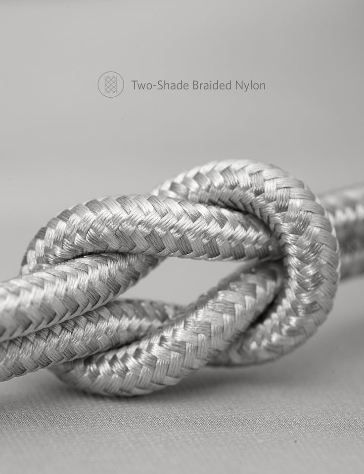 Two-shade braided nylon rope knot on a beige background