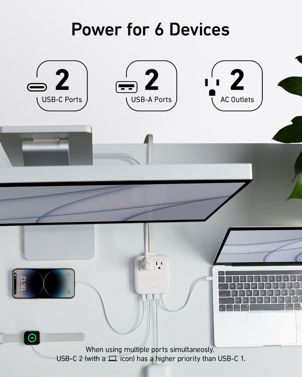 Desk setup with multiple devices connected to a power hub, featuring USB-C, USB-A, and AC outlets.