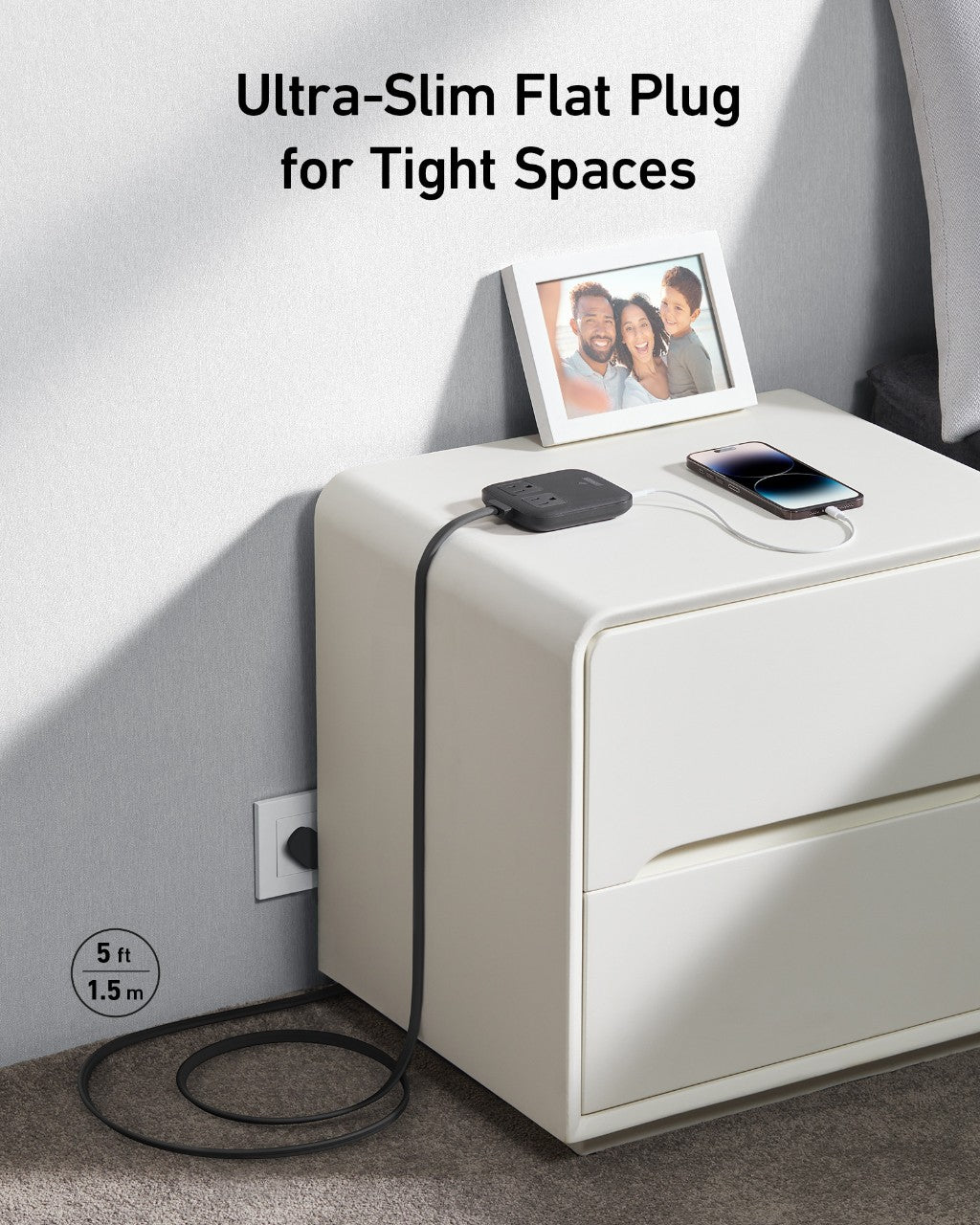 Ultra-slim flat plug for tight spaces on a nightstand with a phone and photo frame.