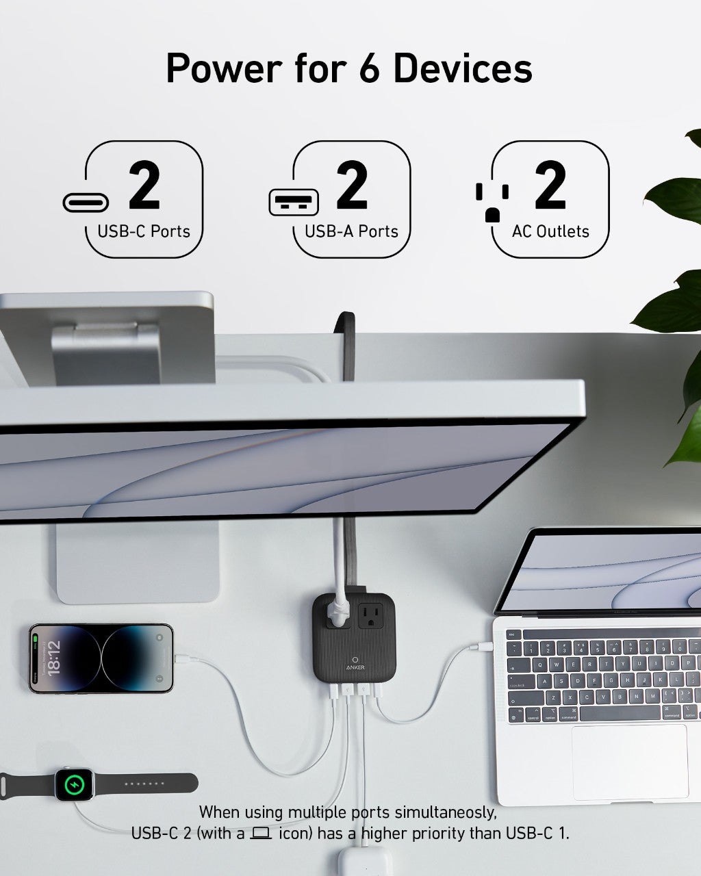Desk setup with multiple devices connected to a power adapter, showcasing USB-C, USB-A, and AC outlet ports.