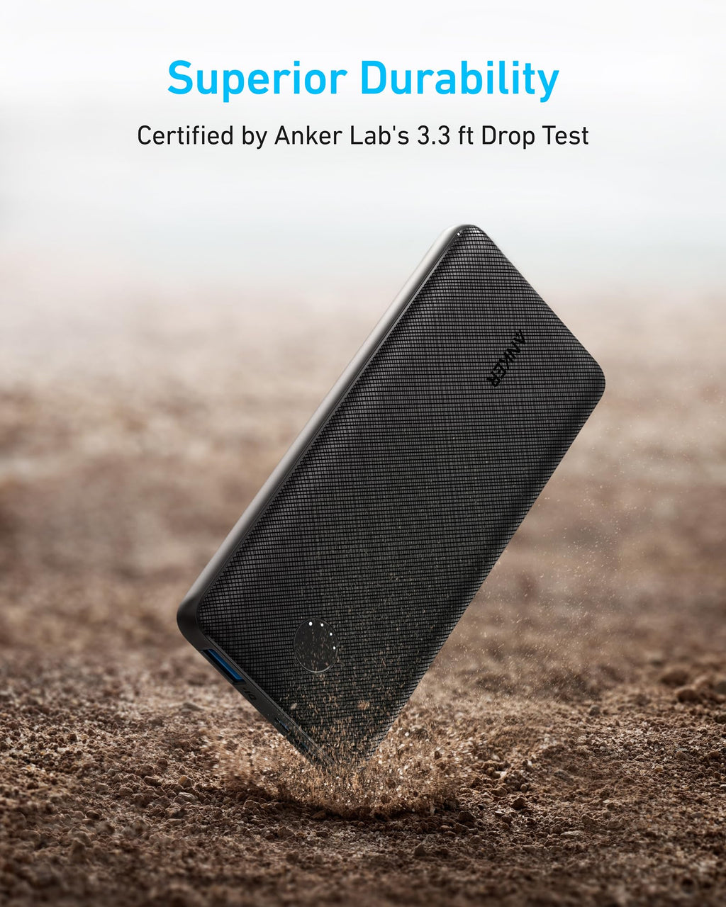 Black power bank being dropped on a sandy surface with 'Anker' branding, labeled 'Superior Durability' certified by Anker Lab's 3.3 ft drop test.