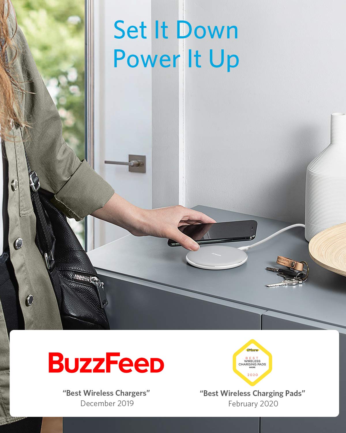 Person using a wireless charging pad with a smartphone, featuring BuzzFeed awards on a blurred background.