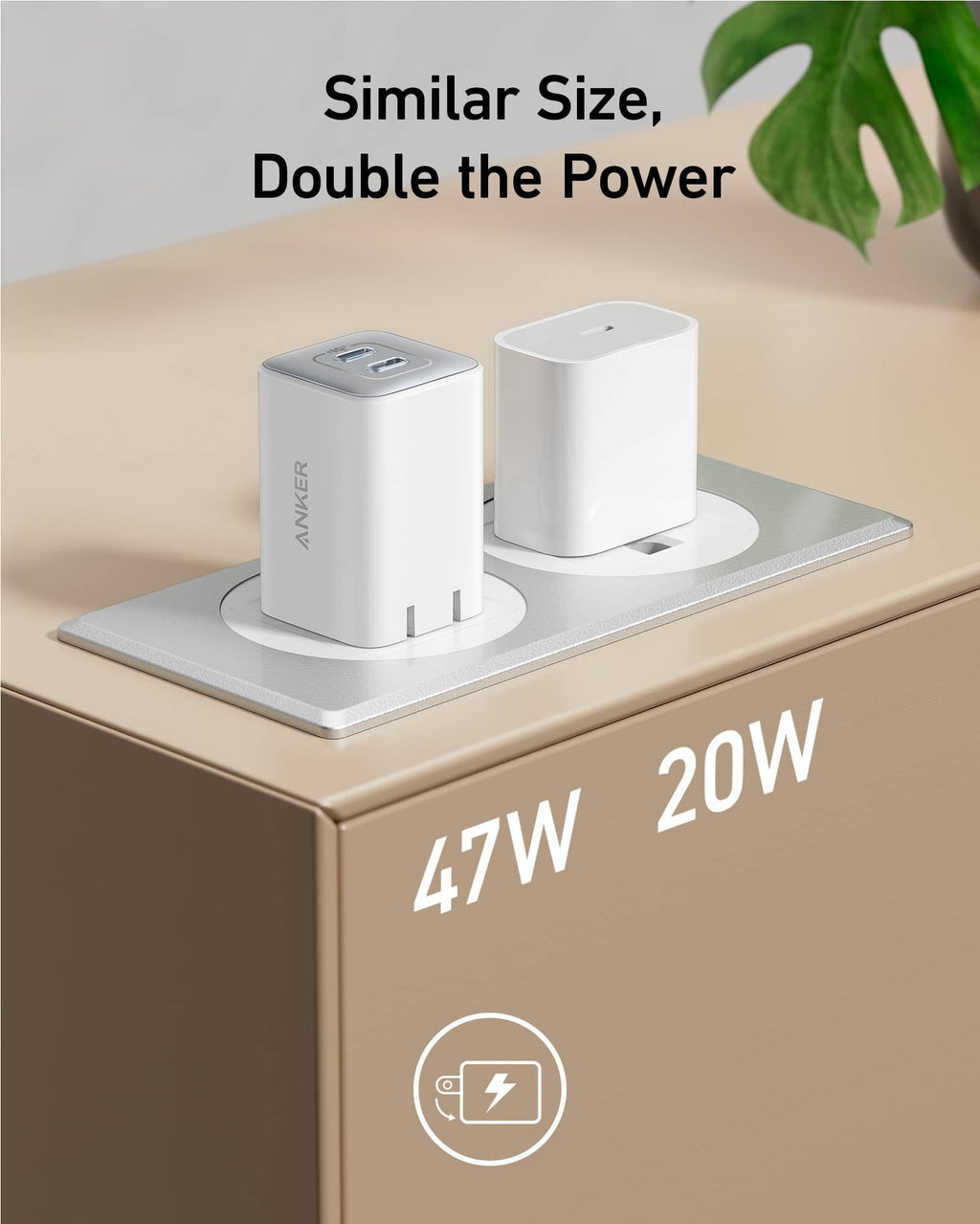 Two power adapters on a surface with text indicating power output and a plant in the background.