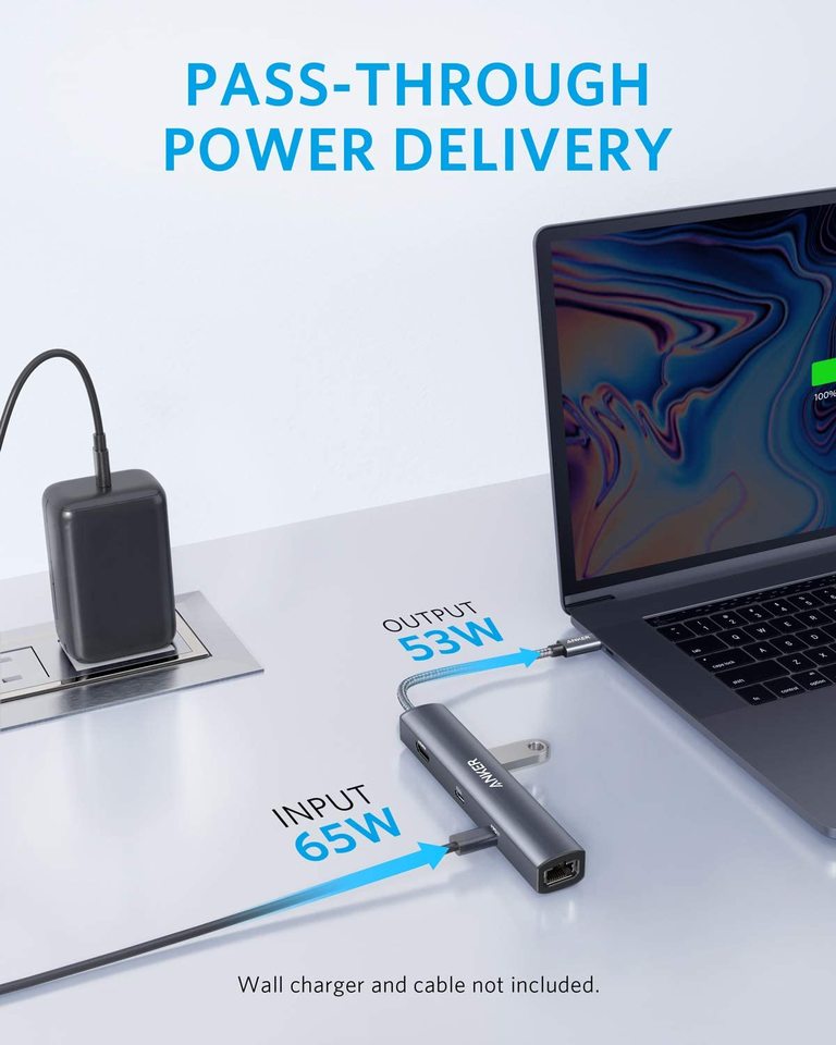 Pass-through power delivery setup with laptop, adapter, and cable on a white surface.