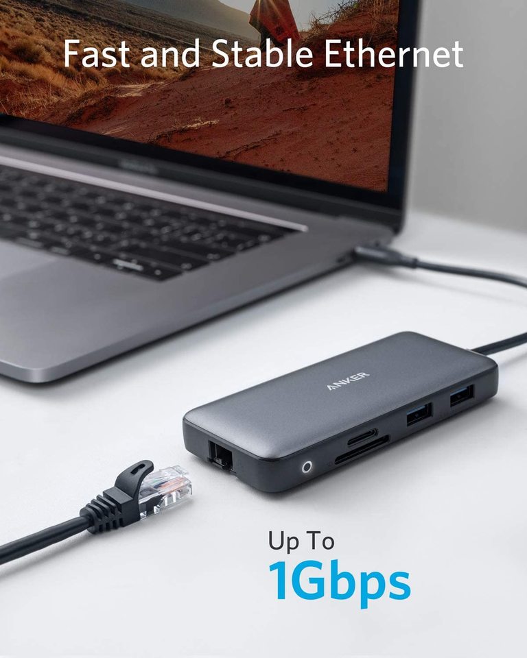 Laptop with a USB hub connected to an Ethernet cable on a white surface, with text indicating fast and stable Ethernet connectivity.