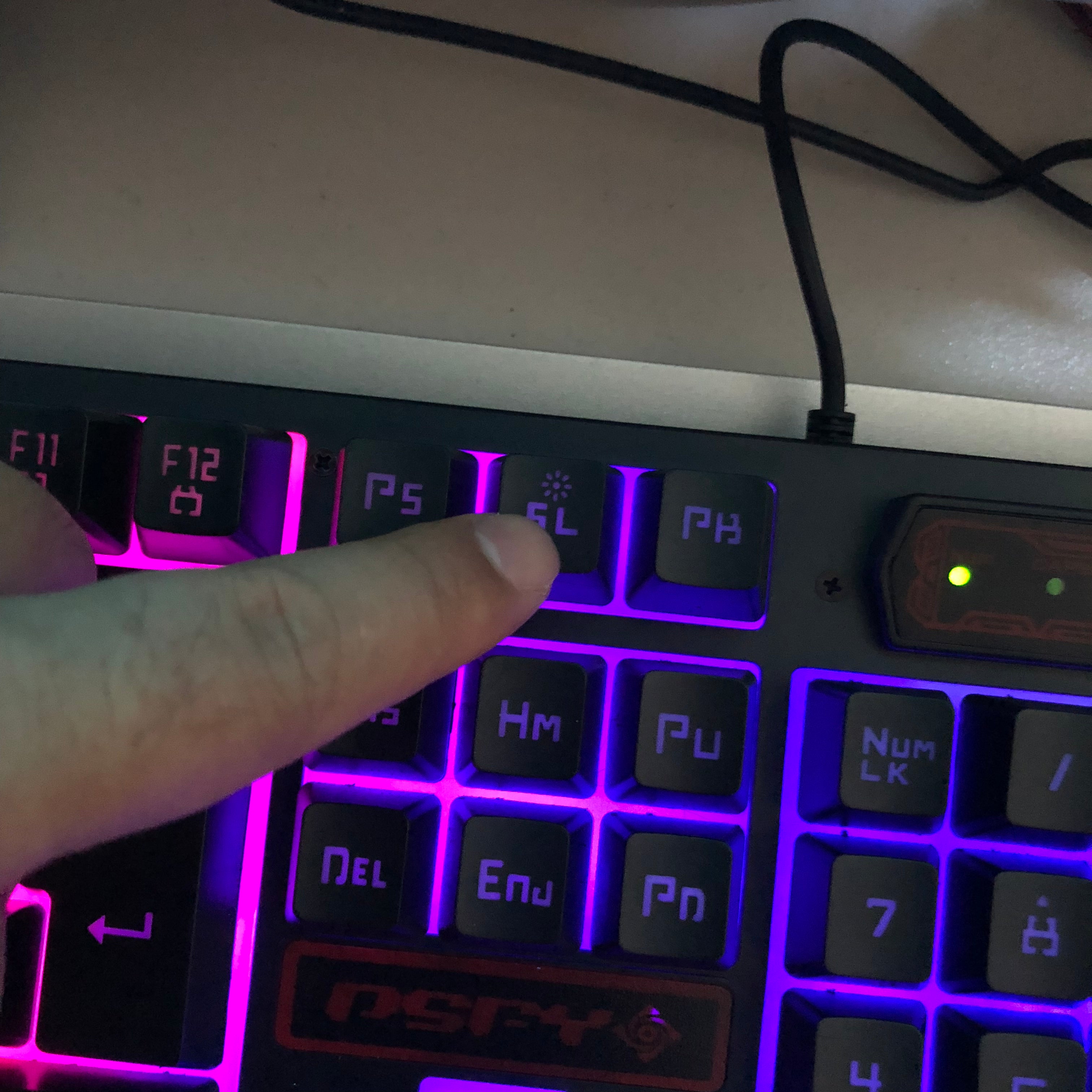 Person pressing a key on a futuristic keyboard with purple backlighting