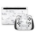 Gaming console and controllers with white camouflage design on a white background