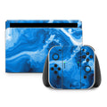 Gaming console and controllers with blue marbled design on a white background