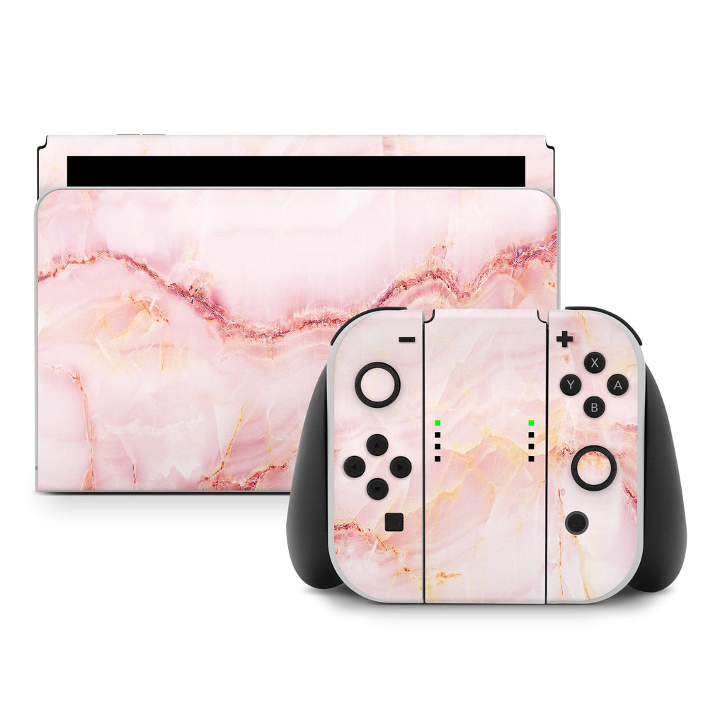 Gaming console and controllers with pink marble design on a white background