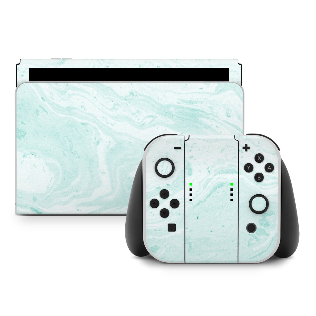 Gaming console and controllers with a light blue marble pattern on a white background