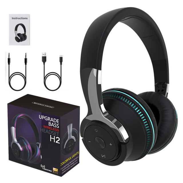 Black wireless headphones with box and cables on a white background