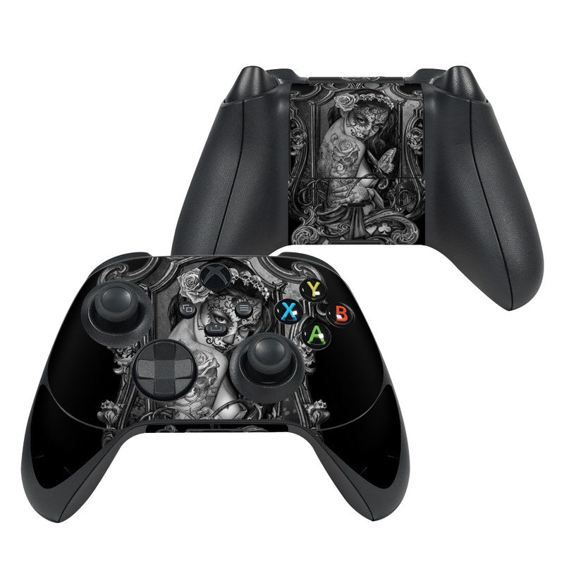 Black gaming controller with intricate design on a white background